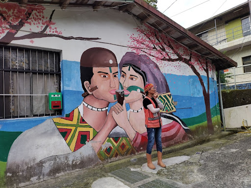 導覽老師於社區以牆上彩繪講解泰雅部落結婚禮俗與有趣軼事